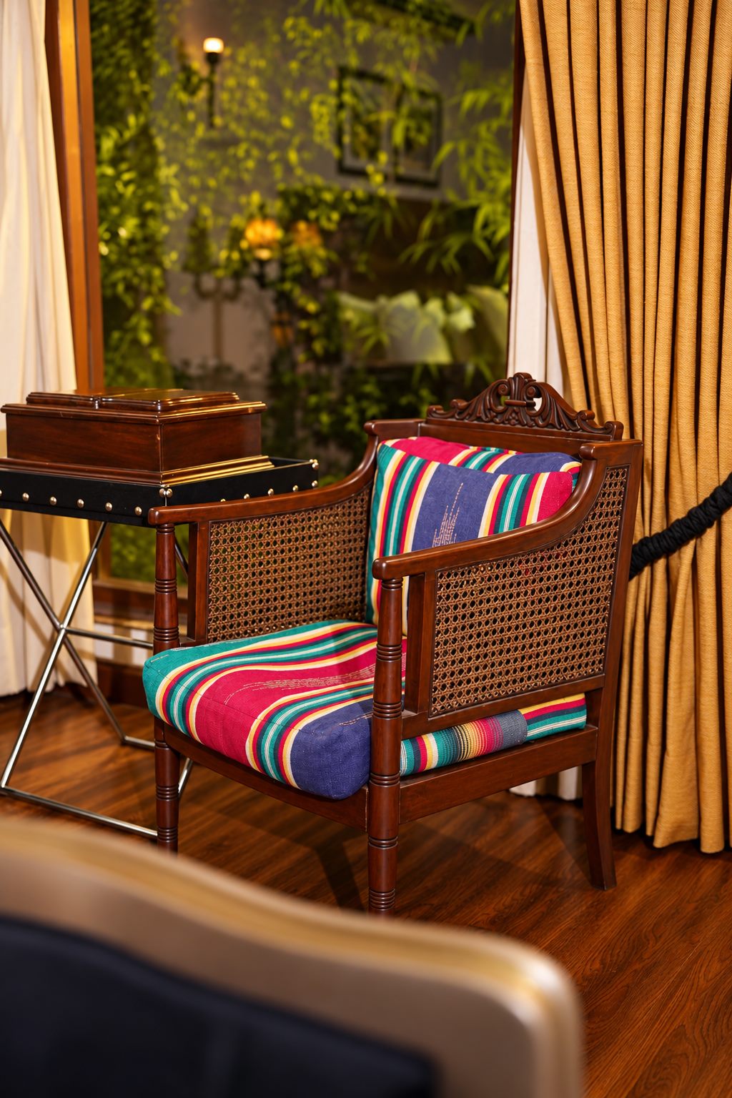 Cane-backed armchair with striped cushion