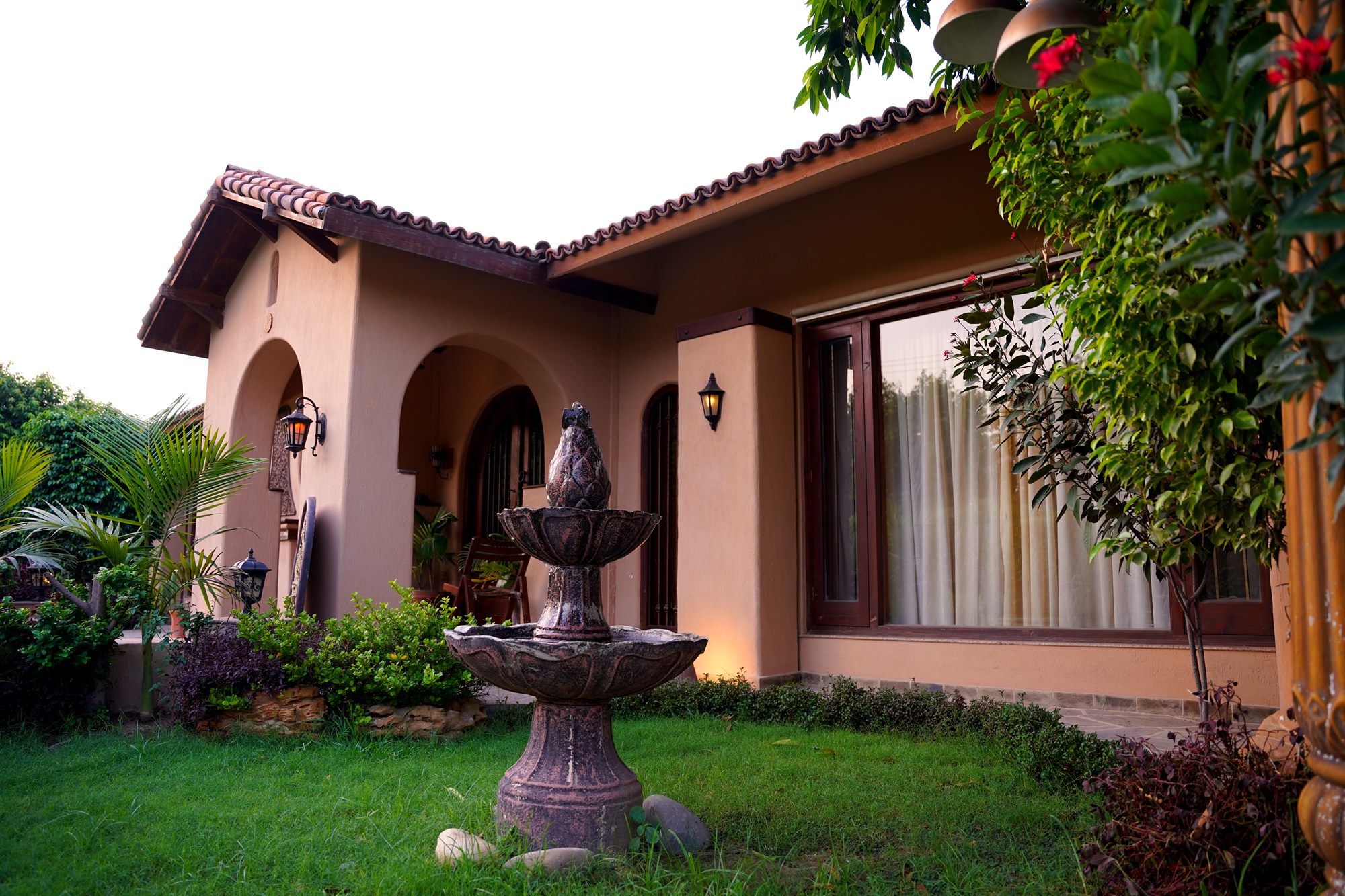 Front garden with stone fountain and arched porch